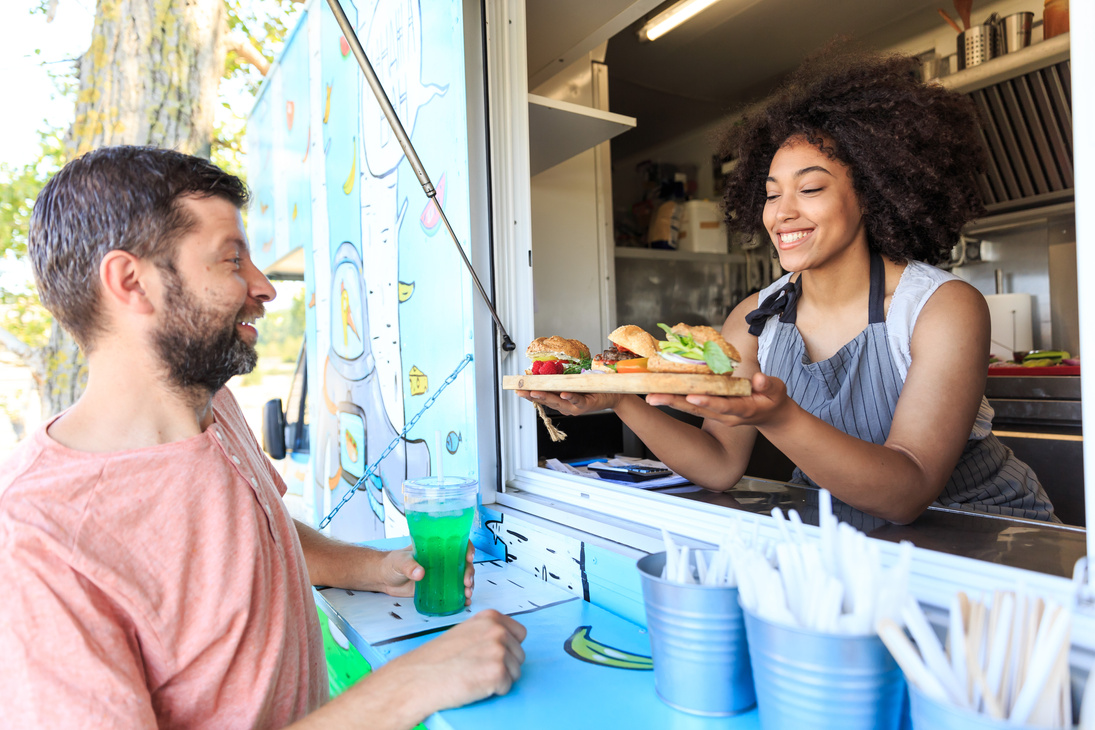 African woman selling burgers in food truck